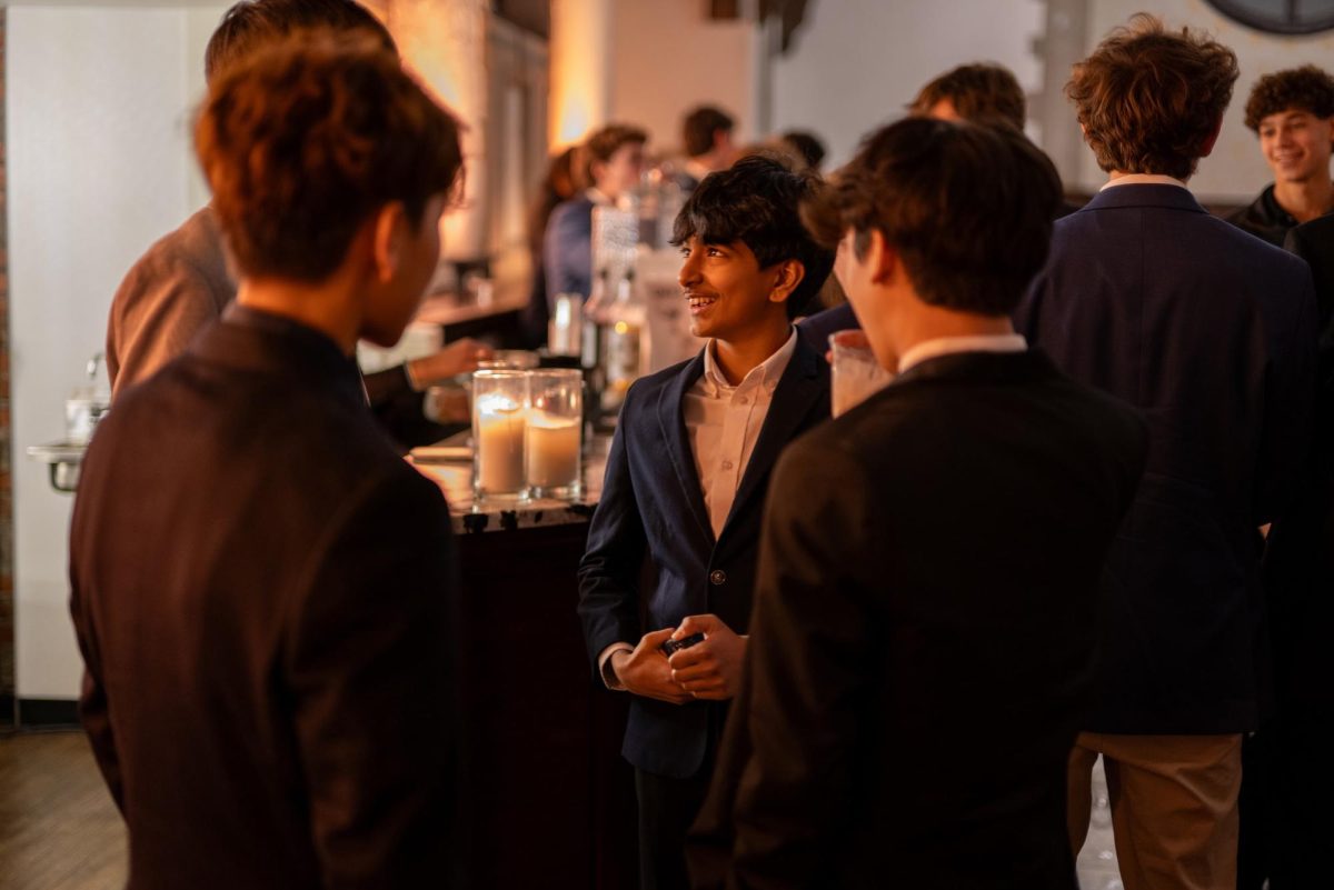 Freshman Siddhant Sirigam smiles while talking to his friends by the drink bar. 